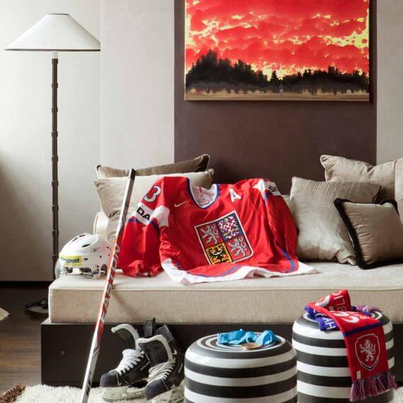 Close-up of hockey jersey, skates and striped stools in a cozy lounge corner — Sun-Kissed in Prague by Prima Design