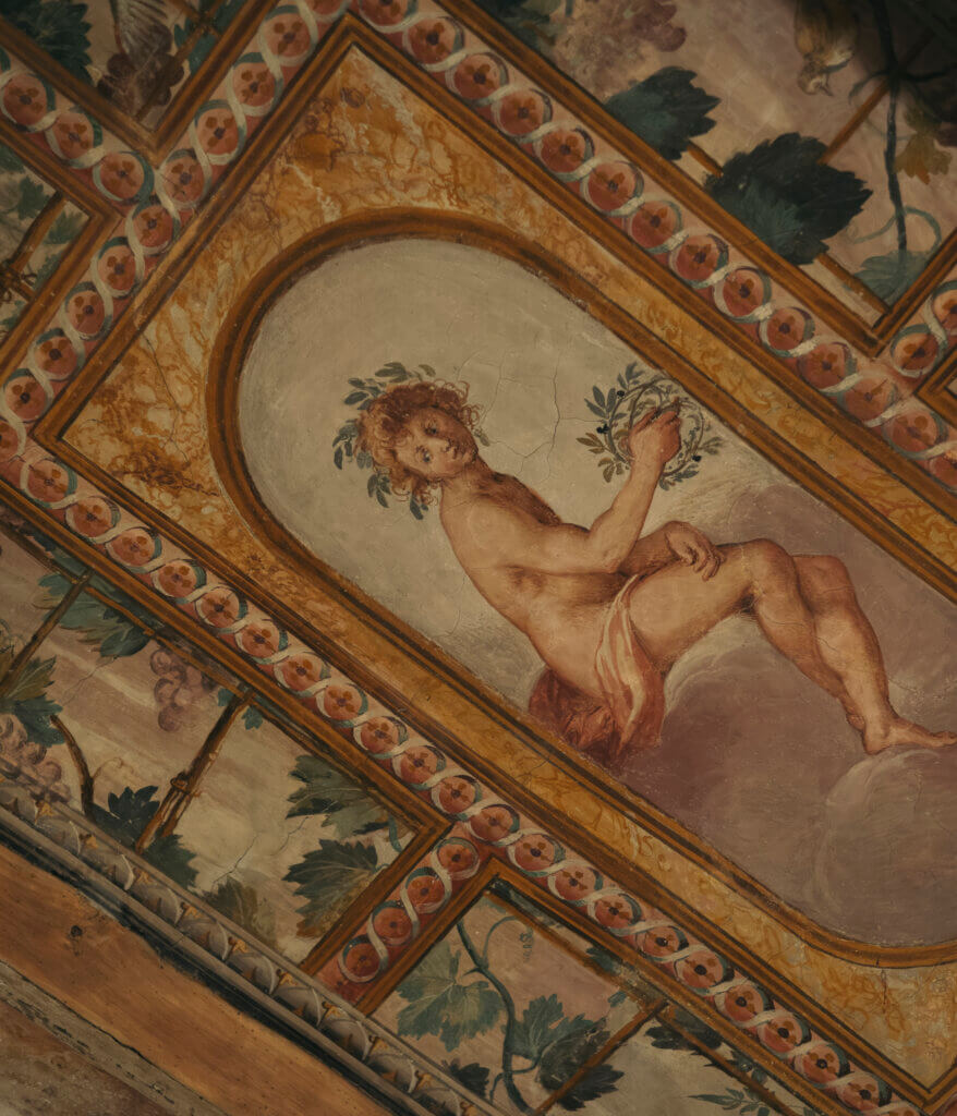 16th-century fresco detail at The James Hotel, Florence, depicting a Renaissance figure surrounded by decorative motifs.