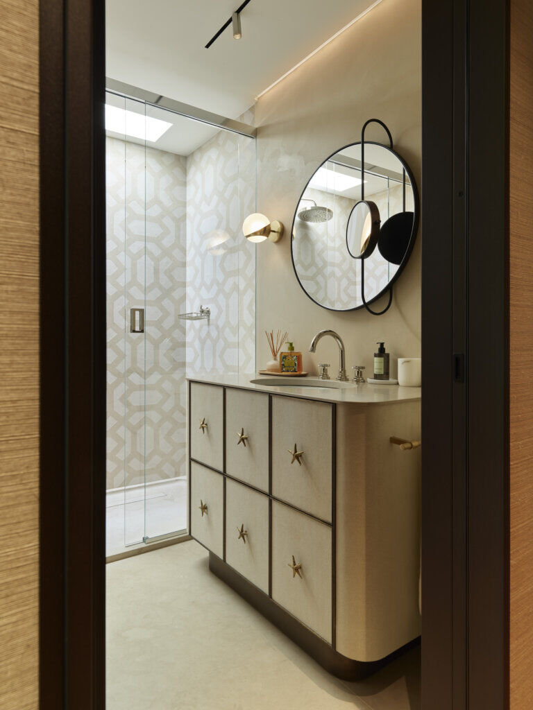 Custom Star-Handle Vanity in Sculptural Bathroom — Saint-Tropez Villa Bathroom vanity with star-shaped brass handles, geometric wall tiles, and round graphic mirror in Primadesign’s Saint-Tropez villa.