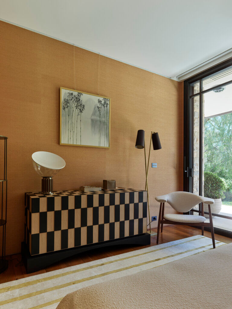 Custom Checkered Cabinet in a Refined Bedroom — Saint-Tropez Villa Custom checkered wood cabinet in the bedroom of the Saint-Tropez villa by Primadesign, featuring a geometric inlay pattern, sculptural lighting, and natural textures with a view of the garden.