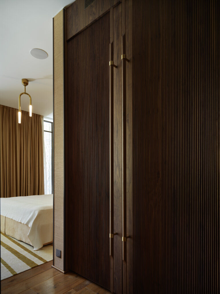 Vertical Wood Detailing in Bedroom — Saint-Tropez Villa Detail of custom vertical wood paneling with brass handles in the bedroom of Primadesign’s Saint-Tropez villa.